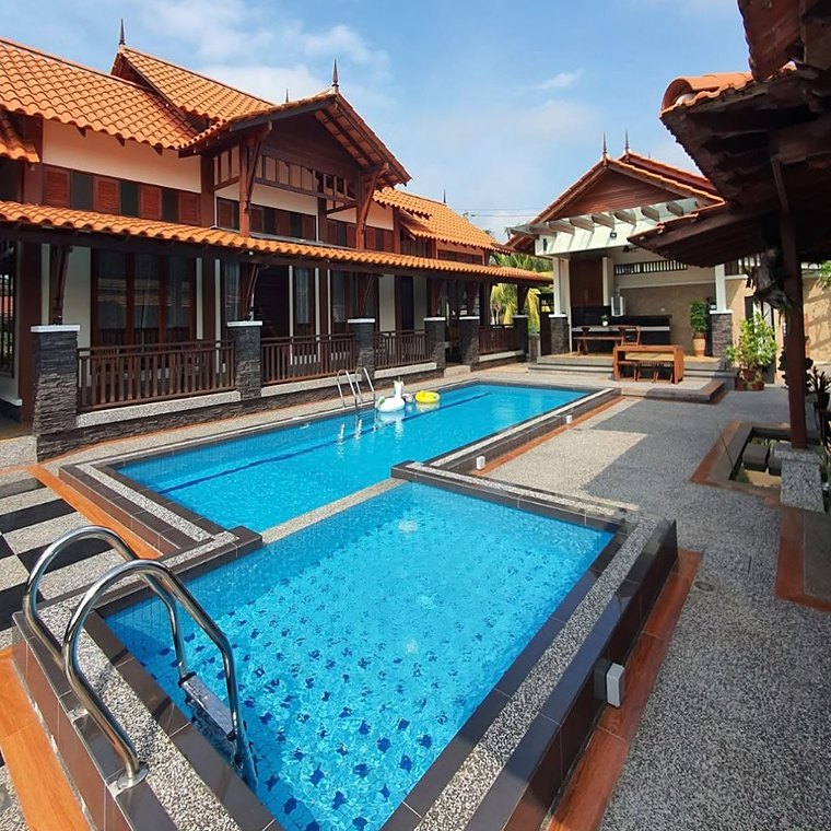 Dua kolam renang dikelilingi rumah kayu berbumbung genting